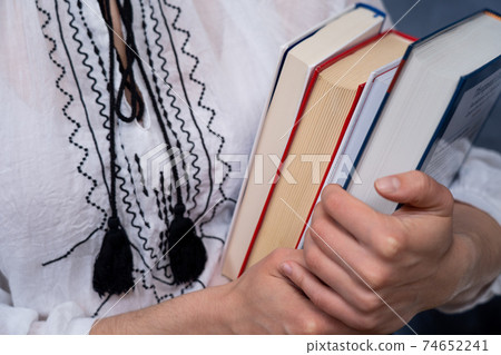 Closeup of Hands Holding A Stack Of Books. Concept of self-development during self-isolation Closeup of Hands Holding A Stack Of Books. Concept of self-development during self-isolation 74652241