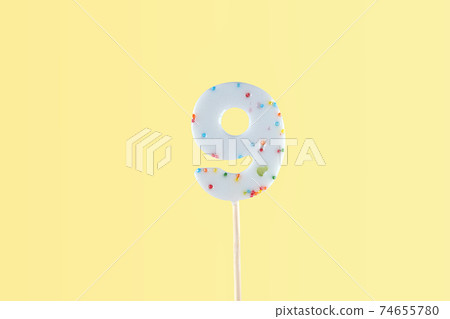 number 9 shaped lolipop on yellow background. anniversary selebration 74655780