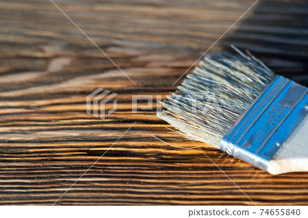 Brush and stain on wood board. Wood texture and paintbrush . housework background Brush and stain on wood board. Wood texture and paintbrush . housework background 74655840