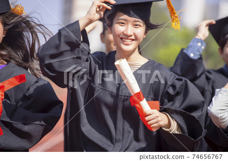 beautiful asian graduation student girl  holding diploma and running on the stadium at school 74656767