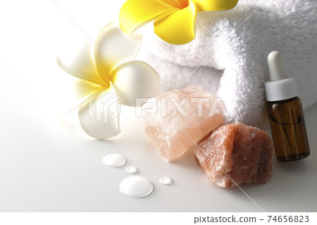 Image shooting of spas and beauty treatment salons using rock salt, aroma oil, white towels, and plumeria flowers (white background) 74656823