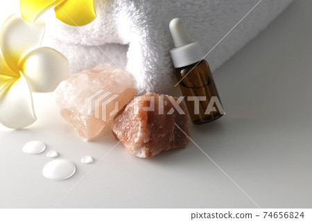 Image shooting of spas and beauty treatment salons using rock salt, aroma oil, white towels, and plumeria flowers (white background) 74656824