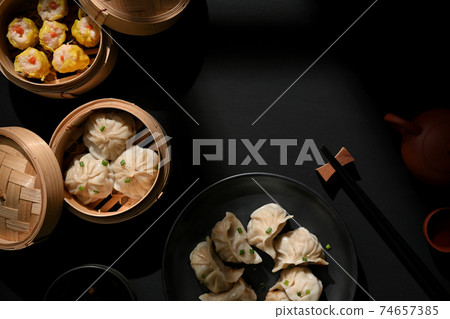 Dimsum on plate and bamboo steamer with dumplings on the table with copy space in restaurant Dimsum on plate and bamboo steamer with dumplings on the table with copy space in restaurant 74657385