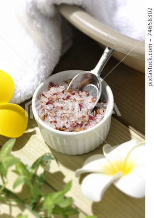 Image shooting of spas and beauty treatment salons using rock salt, white towels, plumeria flowers, and tubs 74658302