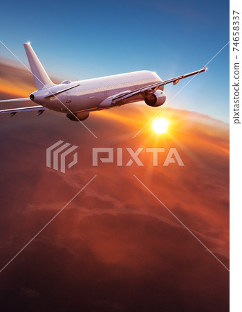 Commercial airplane jetliner flying above dramatic clouds. Commercial airplane jetliner flying above dramatic clouds. 74658337