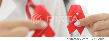 Doctors in white coats hold red ribbon in their hands. Doctors in white coats hold red ribbon in their hands. 74659043