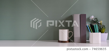 Workspace book, pencil, coffee mug and cactus with green background. 74659635