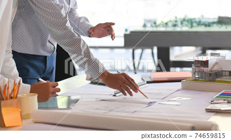 Architecture meeting on draft table with blue print and hose model. Architecture meeting on draft table with blue print and hose model. 74659815