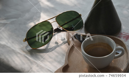 Espresso hot dink and sun glasses on table. Espresso hot dink and sun glasses on table. 74659934