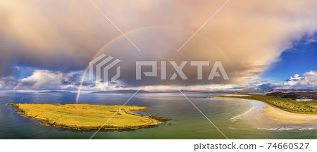 Aerial view of an rainbow above the Atlantic Ocean and Inishkeel by Portnoo in Donegal - Ireland Aerial view of an rainbow above the Atlantic Ocean and Inishkeel by Portnoo in Donegal - Ireland 74660527