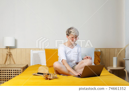 Full body of bright trendy female browsing in laptop, booking and researching travel 74661352