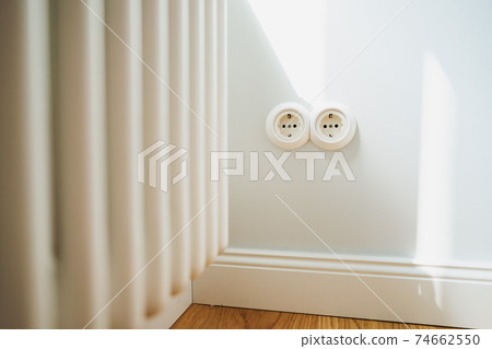 a white electricity socket on a white wall 74662550