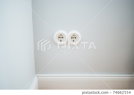 a white electricity socket on a white wall 74662554