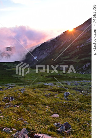 A spectacular view from the vicinity of the summit dormitory of Mt. Hakubadake in summer, the setting sun over Mt. 74663359
