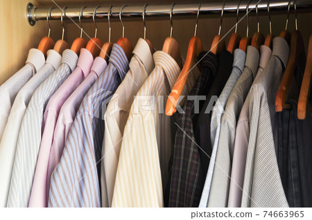 Men's shirts hanging in a wooden wardrobe Men's shirts hanging in a wooden wardrobe 74663965