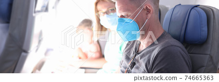 Family read magazine and newspaper in protective mask on plane. Family read magazine and newspaper in protective mask on plane. 74665363