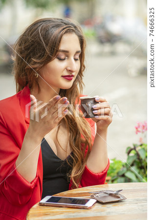 Beautiful young woman sniffing coffee 74666325