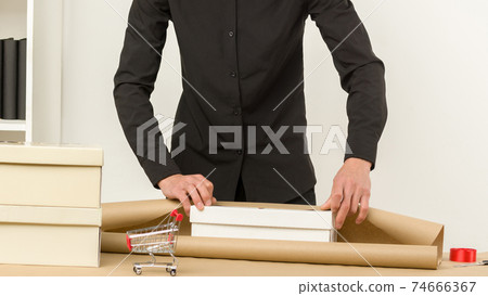 Young male Korean packs postal parcels gift raffle to send by mail. Young male Korean packs postal parcels gift raffle to send by mail. 74666367