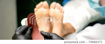 Pedicurist put on new heel file 74666371
