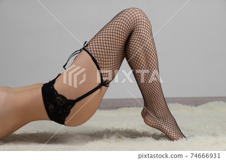 Fine female legs in pantyhose in a fishnet Fine female legs in pantyhose in a fishnet 74666931