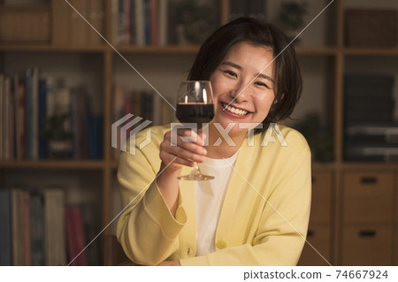 A woman toasting to the camera A woman toasting to the camera 74667924