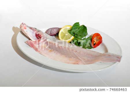 Mackerel fish cut in half in a plate, isolated on white background Mackerel fish cut in half in a plate, isolated on white background 74668463