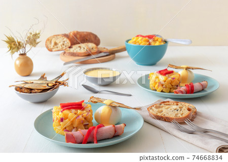 Henri Egg, tasty fresh brunch or snack. Henri Egg, tasty brunch or snack. Boiled eggs and smoked sprats fish with mayonnaise, ham and potato salad. White wooden table, no people. Henri Egg, tasty fresh brunch or snack. Henri Egg, tasty brunch or snack. Boiled eggs and smoked sprats fish with mayonnaise, ham and potato salad. White wooden table, no people. 74668834