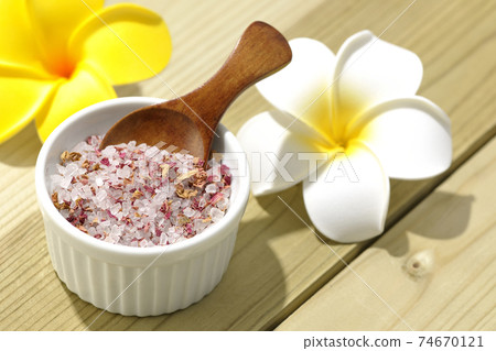 A wooden spoon is stuck in the bath salt in the bowl. A wooden spoon is stuck in the bath salt in the bowl. 74670121