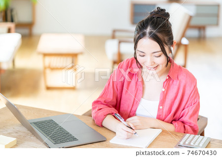 Young woman doing telework in the living room Young woman doing telework in the living room 74670430