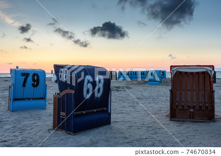 Wicker beach chairs on the beach in Neuharlingersiel, East Frisia, Lower Saxony, Germany Wicker beach chairs on the beach in Neuharlingersiel, East Frisia, Lower Saxony, Germany 74670834