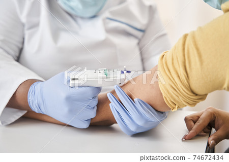 Doctor holding an arm of a young patient 74672434