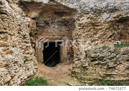 entrance to the ancient catacombs, carved into the rock entrance to the ancient catacombs, carved into the rock 74672877
