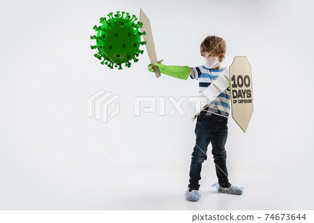 Little caucasian boy as a warrior in fight with coronavirus pandemic, with a shield, a sword and a toilet paper bandoleer. Little caucasian boy as a warrior in fight with coronavirus pandemic, with a shield, a sword and a toilet paper bandoleer. 74673644