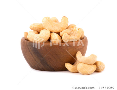 Cashew nuts in wooden bowl, isolated on white background. Roasted cashew nuts. Cashew nuts in wooden bowl, isolated on white background. Roasted cashew nuts. 74674069