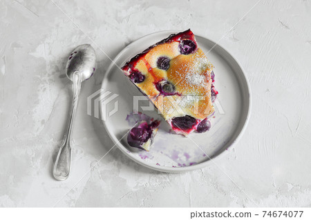 A slice of homemade clafoutis cherry pie - traditional french dessert in a gray plate A slice of homemade clafoutis cherry pie - traditional french dessert in a gray plate 74674077