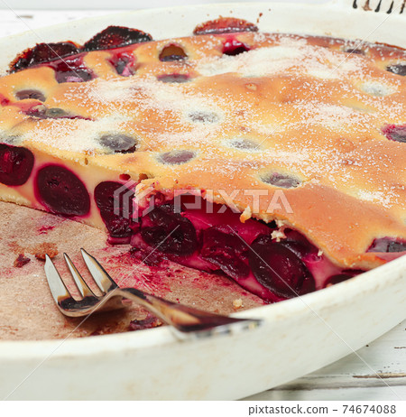 Clafoutis cherry pie - traditional french dessert in a white baking dish 74674088