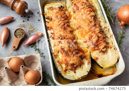 Baked zucchini, stuffed with meat on the gray background Baked zucchini, stuffed with meat on the gray background 74674275