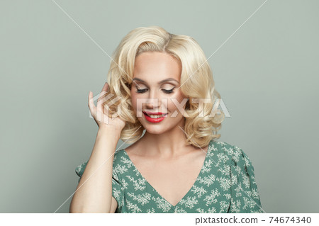 Attractive blonde woman on gray background Attractive blonde woman on gray background 74674340