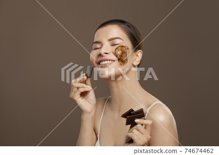 Chocolate spa. Beautiful woman enjoying wellness therapy on brown background 74674462