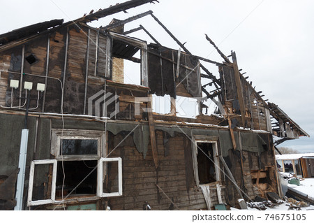 Burnt wooden house. House after the fire. Burned brick house with burnt roof inside view Burnt wooden house. House after the fire. Burned brick house with burnt roof inside view 74675105