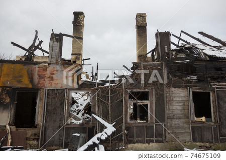 Burnt wooden house. House after the fire. Burned brick house with burnt roof inside view Burnt wooden house. House after the fire. Burned brick house with burnt roof inside view 74675109
