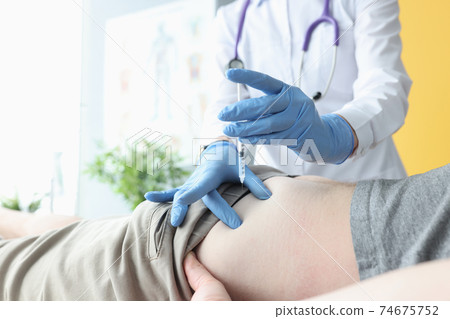 Nurse giving intramuscular injection of medicine into patients buttock 74675752