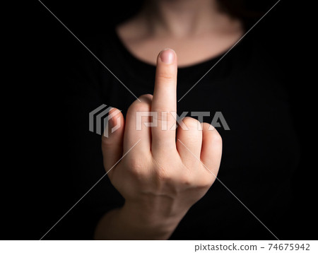 Hand flipping the finger,middle finger up,hand gesturing on dark background, agression,angry,hand, fuck off symbol concept 74675942