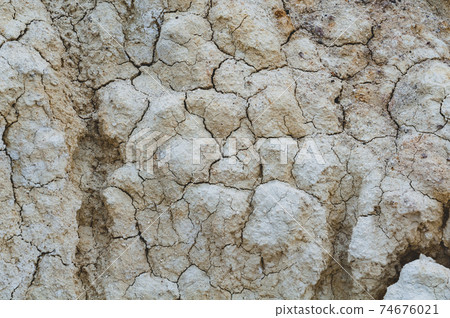 Dry white clay, natural material, atmospheric impact, outdoors. Background cracked, horizontal close-up photo. 74676021