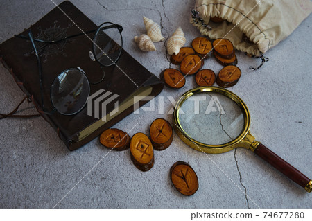 on the table are runes, a book ,a magnifying glass 74677280