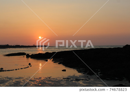 The setting sun and sunset at Hyeopjae Beach in Jeju Island, Korea 74678823