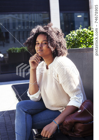 young pretty african girl posing cheerful on city background, lifestyle outdoor people concept young pretty african girl posing cheerful on city background, lifestyle outdoor people concept 74678905
