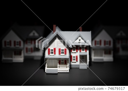 Several Model Houses In A Row With One Spot Lit In The Front Several Model Houses In A Row With One Spot Lit In The Front 74679317