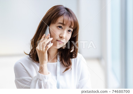 A woman who puts her smartphone on her ear 74680700