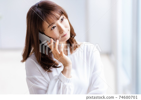 A woman who puts her smartphone on her ear 74680701